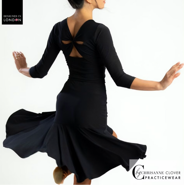 This knee-length Latin skirt showcases a flattering ruched front panel that elegantly scoops and gathers to the left, enhancing the silhouette of the wearer. The flared skirt, complete with a split on the left side, cascades gracefully from the ruched waistband, allowing for fluid movement and a captivating appearance.