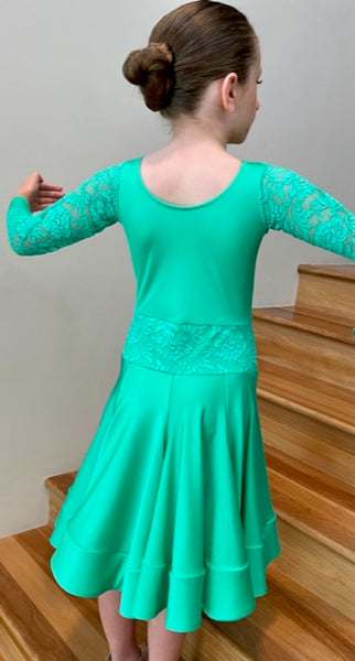 This elegant & eye catching girls Juvenile Dance Dress is ready to wear, made in Australia using quality fabrics by Chrisanne Clover.  Featuring a built-in leotard with lace sleeves with lycra cuffs, feature lace at the waistline, scoop neckline 