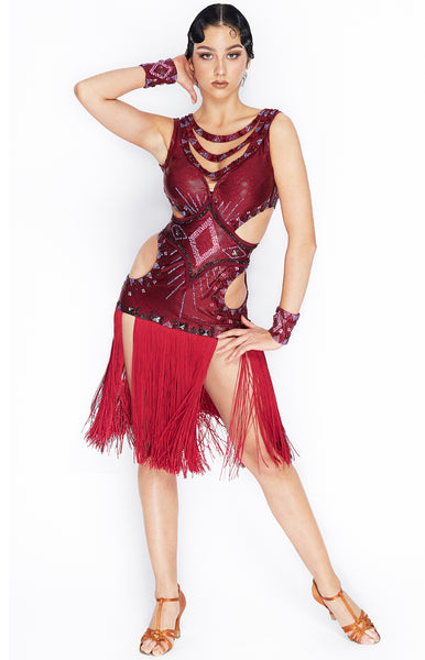 African inspired latin dress in a special burgundy hologram lycra, decorated with different shades and hues of Swarovski crystals, reds, blues, burgundy and siam stones. Built in cups and leotard, cut-out details.  Currently in stock size XS-S.  This stunning, fully completed, ready to wear Latin DanceSport Dress can be created in any colour and size.